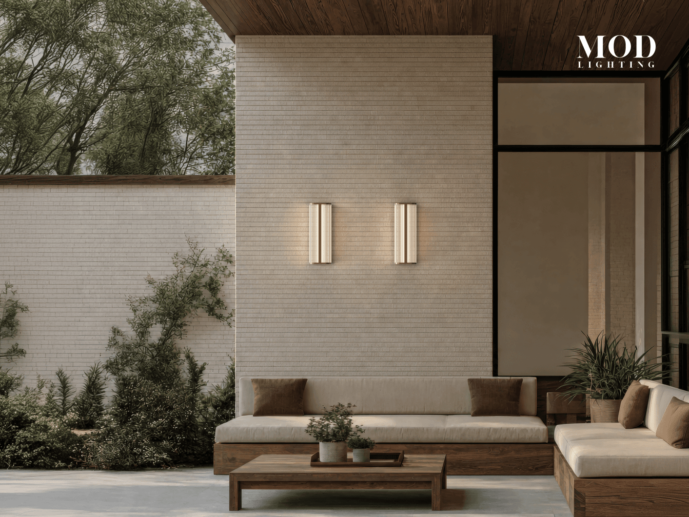 Arden black outdoor sconces, slim fluted bars glowing up and down on a brick wall above a patio sofa